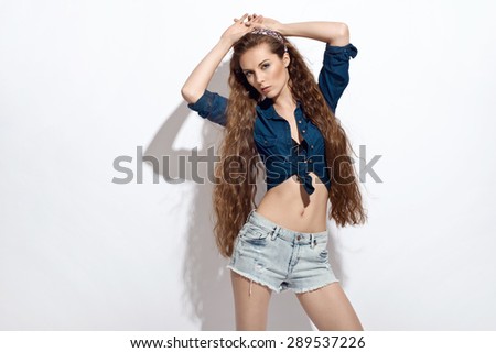 Beautiful young woman in jeans shirt and shorts. Summer fashion photo. Long healthy hair