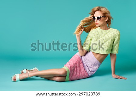 Beautiful blonde young woman in nice clothes, round white sunglasses, high heels sandals. Fashion Photo