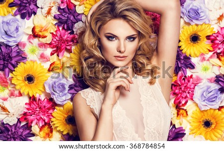 Beautiful sensual woman in laced lingerie on colorful wall of flowers. Beauty photo, nice hair