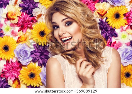 Portrait of beautiful woman with wide smile, white teeth, posing in laced lingerie on colorful wall of flowers. Beauty photo, nice hair
