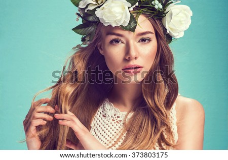 A portrait of a young beautiful woman with white flowers on the head. Spring fashion photo