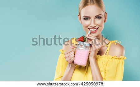 Beautiful young blonde woman in yellow top drinking strawberry smoothie with a straw in a summer day. Healthy organic drinks concept. People on a diet.