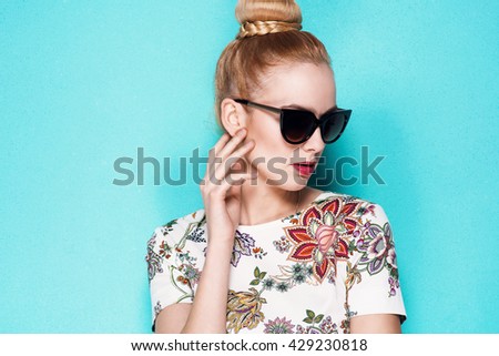 beautiful young blonde woman in nice spring dress, elegant black sunglasses posing in a studio. Fashion spring summer photo