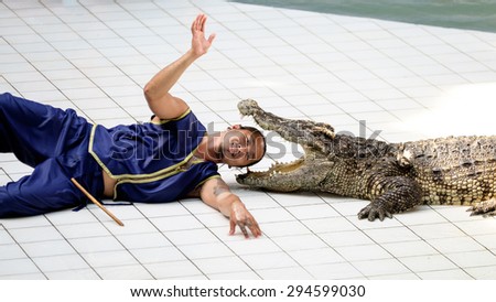 KANCHANABURI, THAILAND - June 13: Trainer puts his head in a crocodile mouth at show in Safari Park on June 13, 2015. This popular and exciting show is very famous among tourist and Thai people.