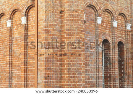 Corner of ancient brick building with arches,ornaments and arched windows