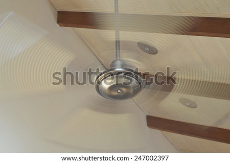 Four-bladed ceiling electric fan rotating at high speed
