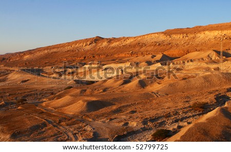 Car road along the Dead Sea coast, among sandy dunes.The landscape of the desert, morning sun shining.