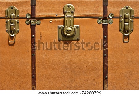 Front view of vintage worn-out  leather suitcase  with three metallic locks in retro style.