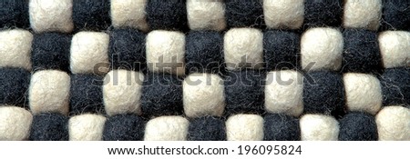 Closeup of decorative abstract carpet texture with colorful bright beads of synthetic fibers. Black and white tones. Useful for background.