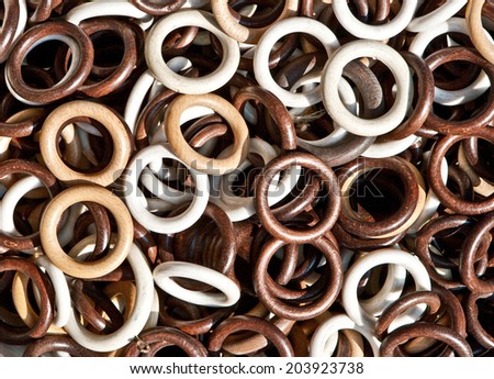 Background of white, beige and brawn wooden rings for curtains