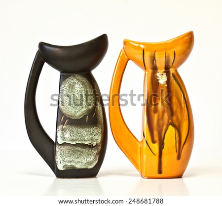 Israeli ceramic pair in black and orange : two jugs of 1950-th years. Glazed  abstract images. Symbolizes couple: He and She; brother and sister, bride and groom etc. Isolated on white.