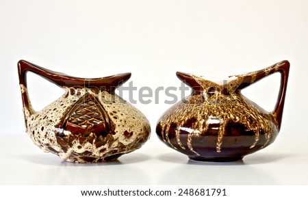 Israeli ceramic pair in bright brown tones: two jugs of 1950-th years. Glazed and curved surfaces. Symbolizes couple: He and She; brother and sister, bride and groom etc. Isolated on white.
