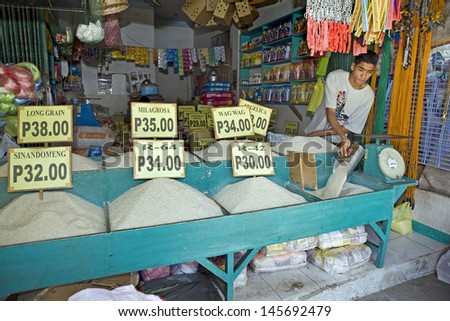 Barretto, Philippines - December 22, 2011 - Unidentified Filipino Man At The Public Market Sells White Rice On December 22, 2011 At Barretto, Philippines. Rice Is An Essential Food Eaten Daily.