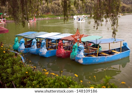 Colorful dragon shaped paddle and row boats for rent on the pond in Burnham Park, Baguio City, Luzon, Philippines.