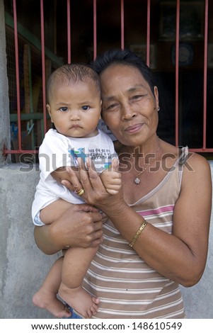 PHILIPPINES - CIRCA 2012 - Unidentified Filipino grandmother holding her grandson in the Philippines on circa 2012. Strong family bonds characterize Philippine society at all economic & social levels.
