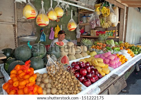 LUZON, PHILIPPINES - CIRCA 2011 - Unidentified market vendor sells fruit from his market stand circa 2011 in Luzon, Philippines. Fresh fruit and vegetables are abundantly available to people.