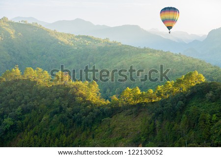 green forest mountain with hot air balloon