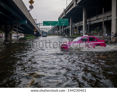 BANGKOK - NOVEMBER 5:   Taxi driving through flood water on Phahonyothin  rd., in Thai flood crisis, Central of Bangkok on November 5, 2011