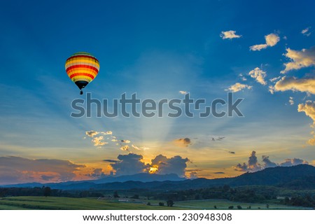 Hot air balloon over the fields at sunset