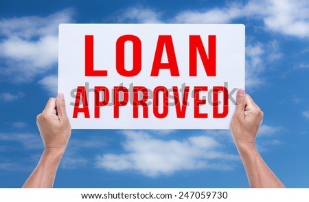 Two hands holding brown cardboard with loan approved on blue sky background