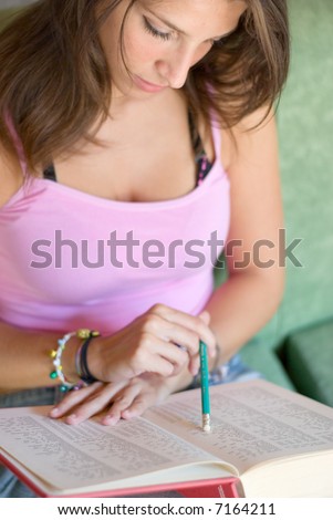 Girl student consults analytic index of an university book that is studying