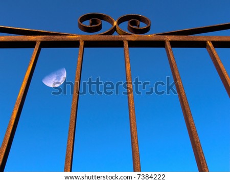 The moon behind the bars of a cell of a prison