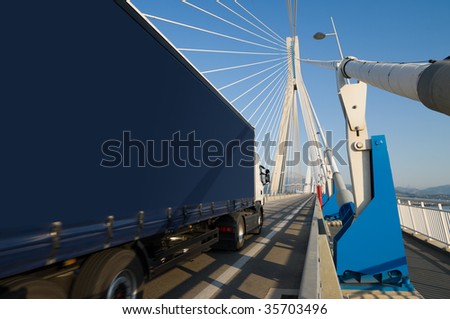 A truck through the pylons of suspension of a bridge. You can use the side of trucks to insert a text