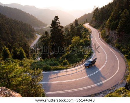 pickup crosses mountain road winding in twilight