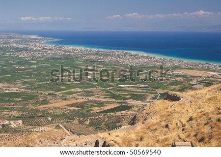 aerial view on the cultivated land and on the suburbs urban along marine coast of gulf of Corinth from the rock of Acrocorinth in Greece