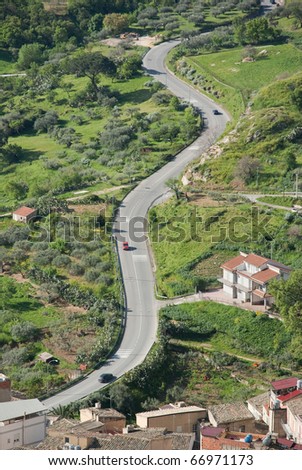 stock photo aerial view of cars are going through a winding rural road