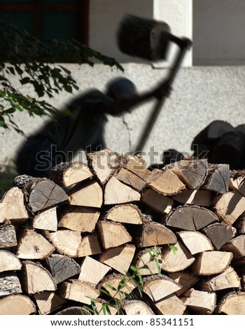 firewood and silhouette of a lumberjack in action