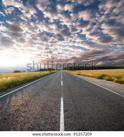 straight road and dramatic sky at the sunset