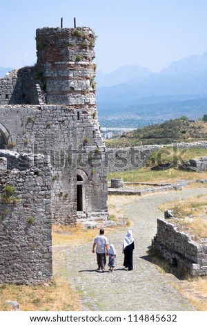 muslim family walks through the ruins of the minaret added by the Turks to the St. Stephens Church, turning it in a mosque, in the Rozafa Castle, Shkoder