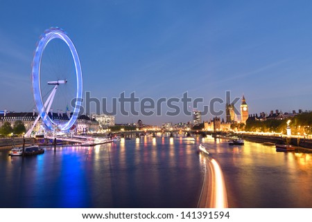 London Eye and Big Ben on the banks of Thames River at twilight
