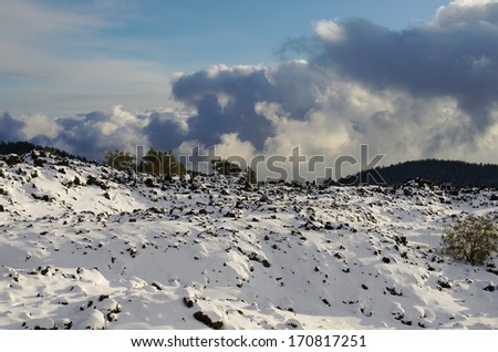 cold lava covered by snow in Etna Park, Sicily