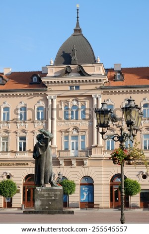 NOVI SAD, SERBIA - AUGUST 03: the bronze statue of Svetozar Miletic and neoclassical and baroque renaissance architecture in the Liberty Square of Novi Sad. Shot in 2014