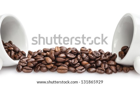 heap of coffee beans with two cups, isolated on white