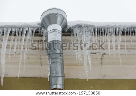 icicles on the house roof, drain pipe
