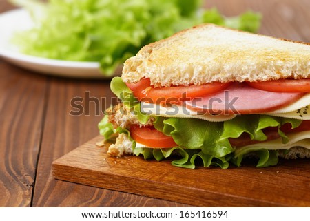 toasted sandwich with ham, cheese and vegetables, on wooden table
