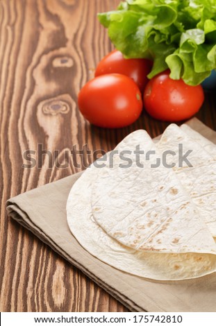 wheat tortillas with vegetables on old wooden table rustic style