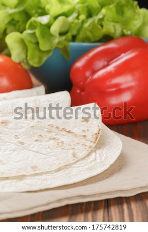 wheat tortillas with vegetables on old wooden table rustic style