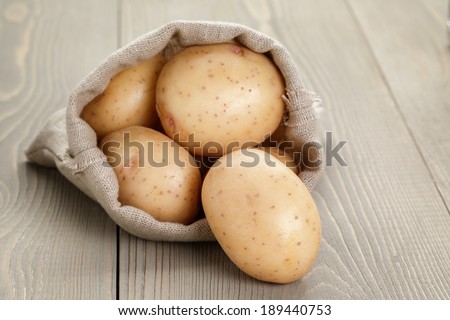 baby potatoes in sack bag on wood table