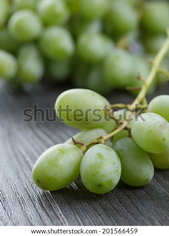 ripe green grapes on black wood table, close up