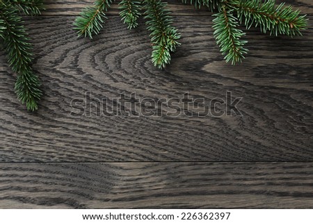 fir branch on stained oak table from above, christmas background
