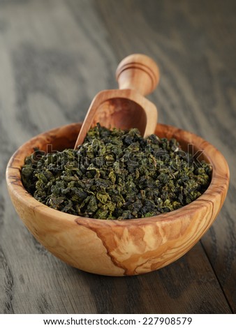 oolong green tea in olive bowl, on oak table