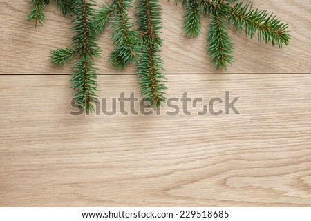 christmas tree branch on oak table, rustic background