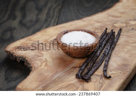 bourbon vanilla pods with white sugar on wood table, simpe dark photo