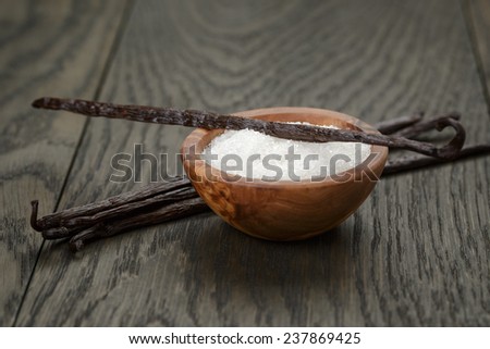 bourbon vanilla pods with white sugar on wood table, simpe dark photo