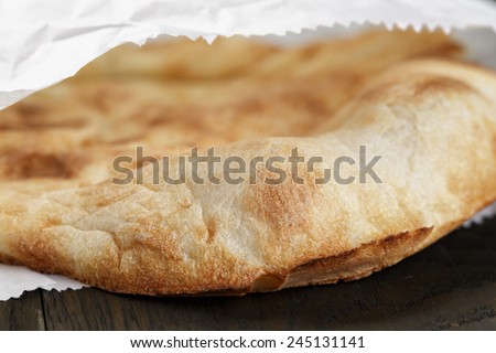 close up of freshly baked flat bread in paper bag