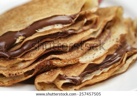 thin crepes or blinis with chocolate cream on plate